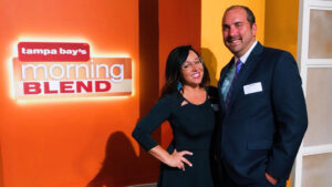 Lisa Williams, President of Evolve & Co, and a client standing in front of Tampa Bay's Morning Blend Sign