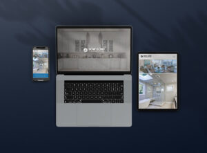 A phone, laptop, and tablet on a blue surface with website designs displayed