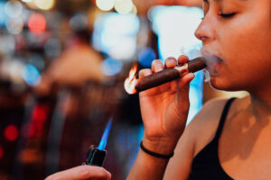 lighting woman's cigar at Ruby's Elixir and Central Cigars in downtown St. Petersburg, FL